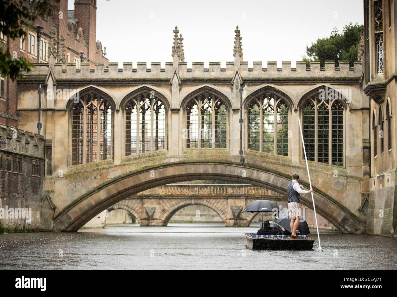 A Punt approaches the Bridge of Sighs along the river Cam at St John's College at  the University of Cambridge. Stock Photo