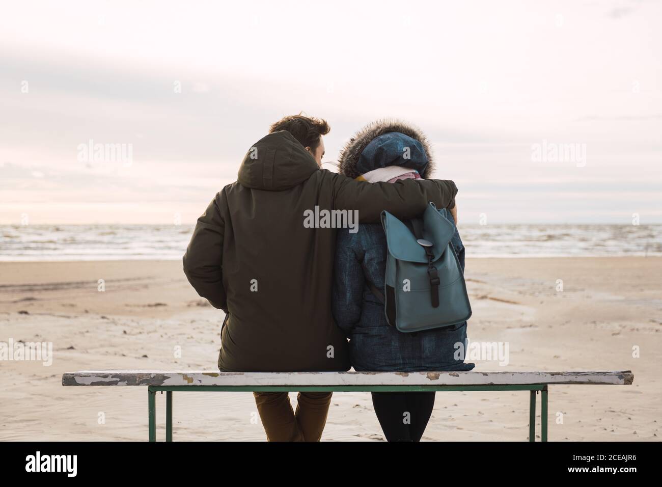 couple sitting looking the sea Stock Photo - Alamy