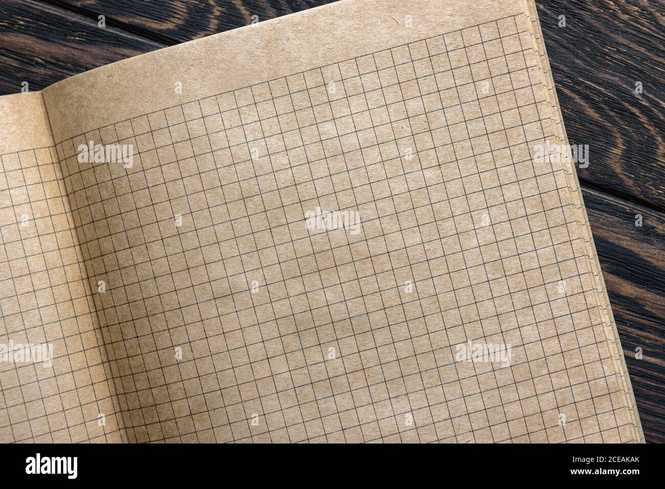 Grid paper of notebook background, open sketchbook with blank pages. Top view of vintage graph sheet on wooden desk, texture squared paper of school n Stock Photo