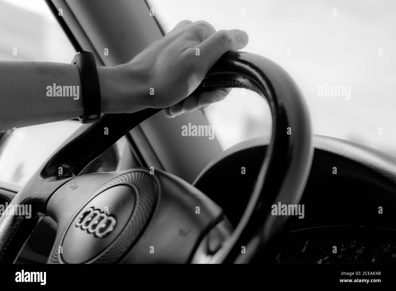 Audi driver with hand on steering wheel black and white photo Stock Photo