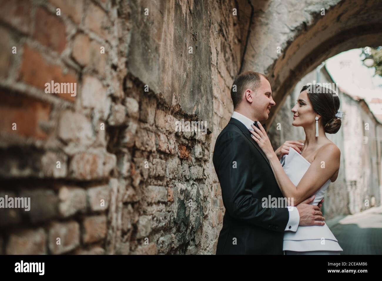 Married couple hugging near old wall Stock Photo