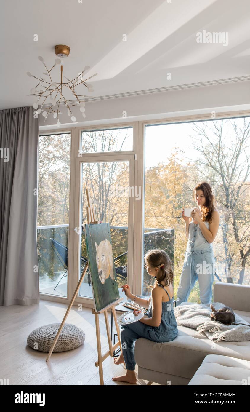 Woman with coffee and girl drawing painting Stock Photo