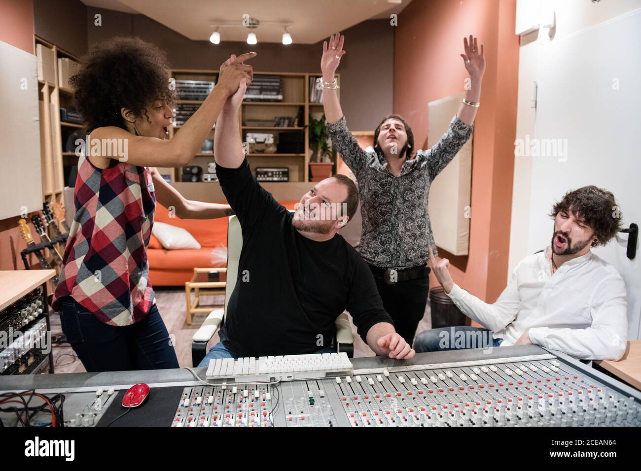 Group of people rejoicing over success and having fun�after recording music in studio Stock Photo