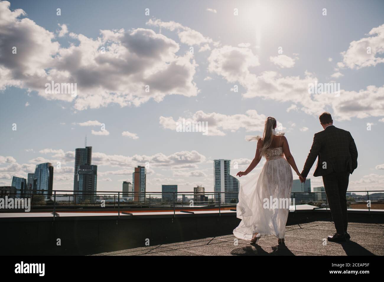Bride and groom on a roof with a skyline background Stock Photo - Alamy