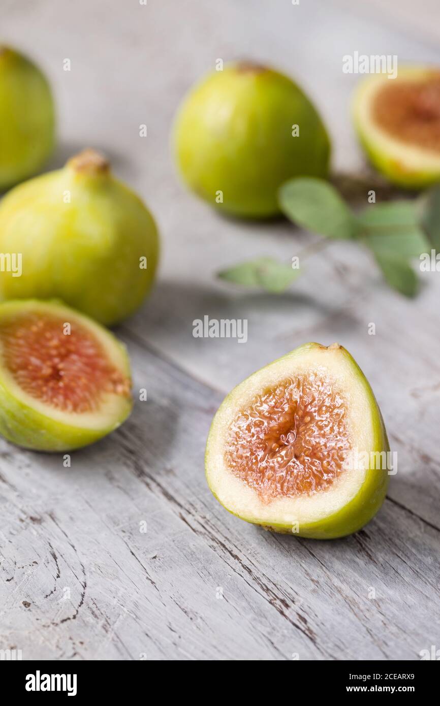 Close-up green unripe fig fruit on wooden table. Stock Photo