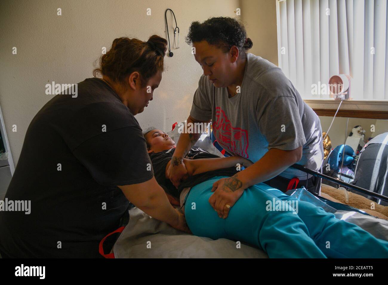 Sacramento, California, USA. 10th Feb, 2019. Felicia Brent-Velasquez is dressed by her mom Felicia Clark, right, and sister Paulina, left, who she depends on since being paralyzed from the neck down on Feb. 10, 2020. 'It's a lot of day to day care and I didn't get trained for this, nobody said hey Felicia you should go to schooling for nursing cause you might need it one day,'' said Clark who manages all the care for her quadriplegic daughter. Credit: Renée C. Byer/ZUMA Wire/Alamy Live News Stock Photo