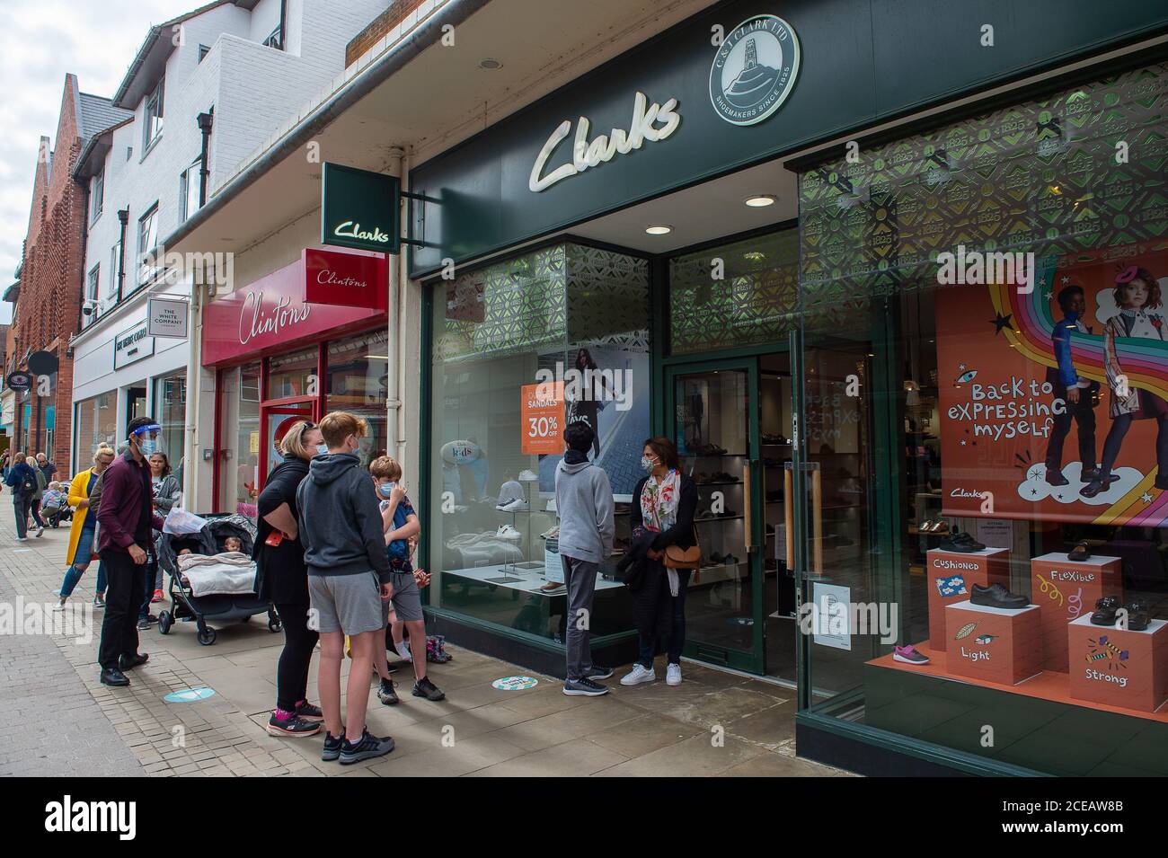 Windsor, Berkshire, UK. 31st August, 2020. Parents leave it very last minute to get new school shoes for their children as they queue outside Clarks shoe shop. Windsor was very busy today with tourists and locals visiting the town on a warmer than expected August Bank Holiday Monday. Credit: Maureen McLean/Alamy Stock Photo