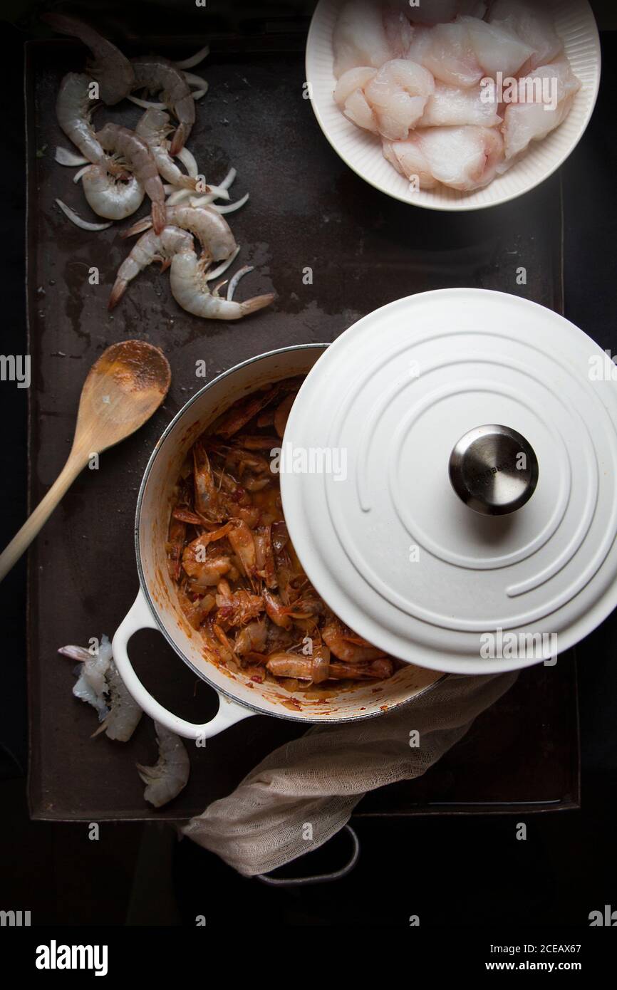 Top view of white pot with tasty prepared dish on a table. Stock Photo