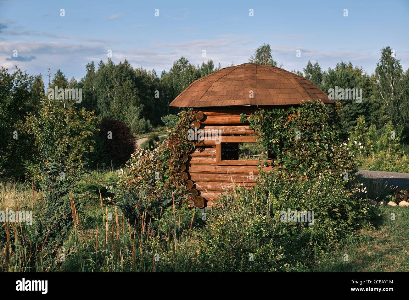 Wooden rustic gazebo in summer park. Stock Photo