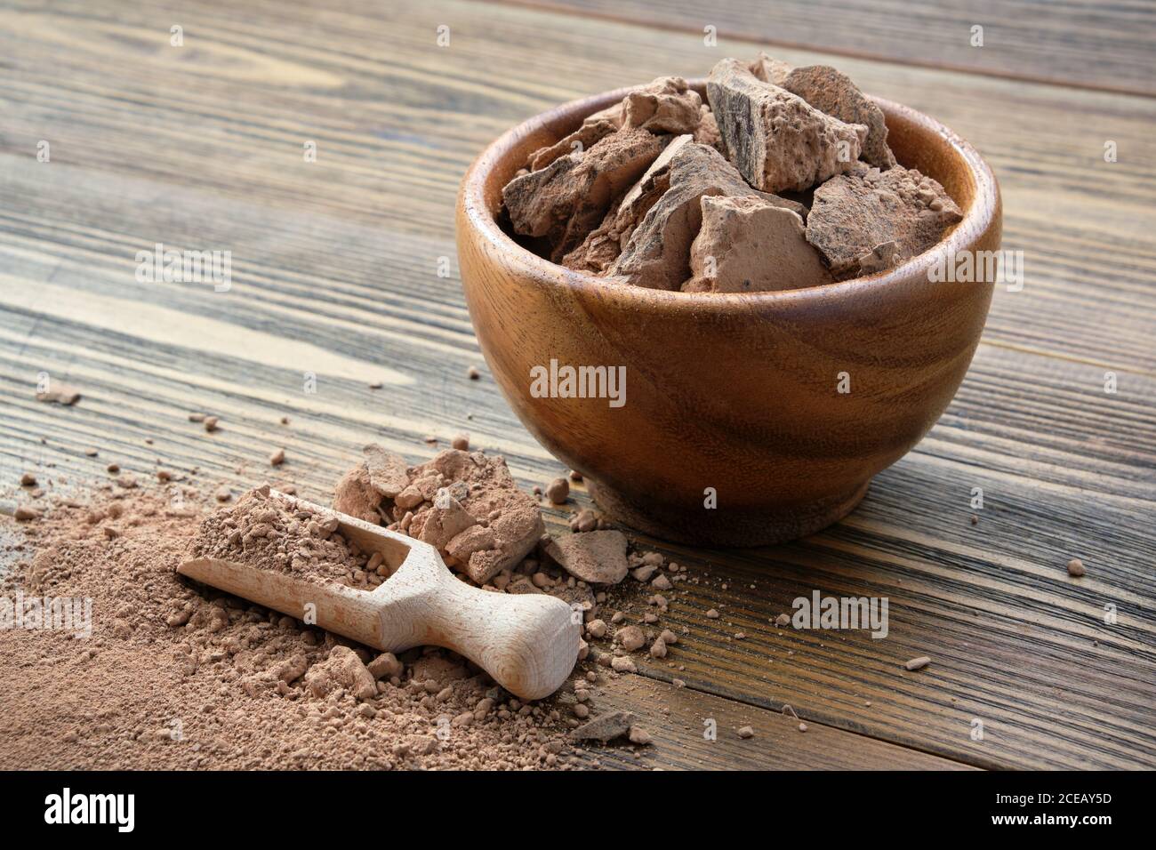 Wooden bowl of natural organic grated cocoa. Stock Photo