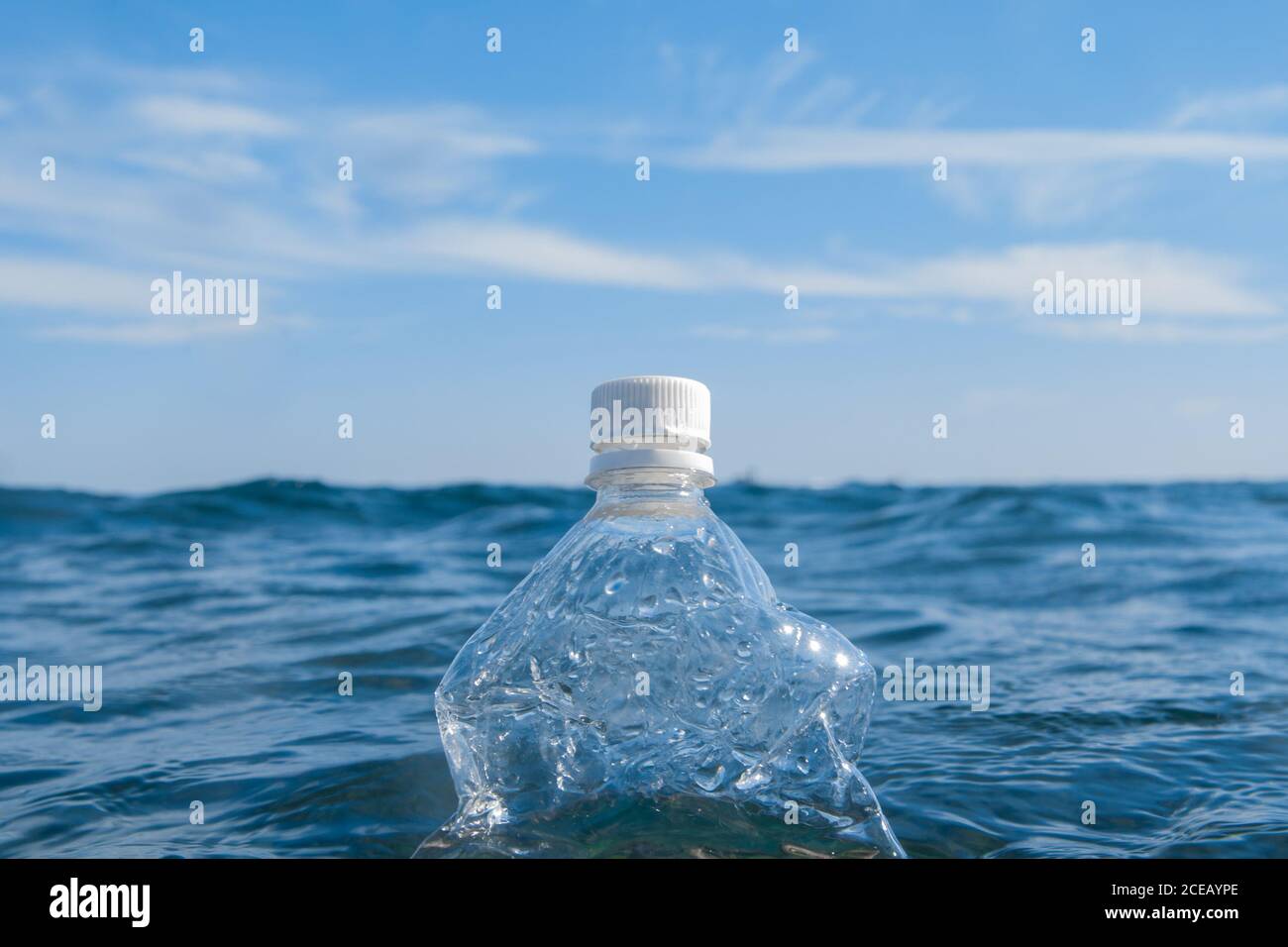 A plastic bottle floats on the surface of the water in the open sea