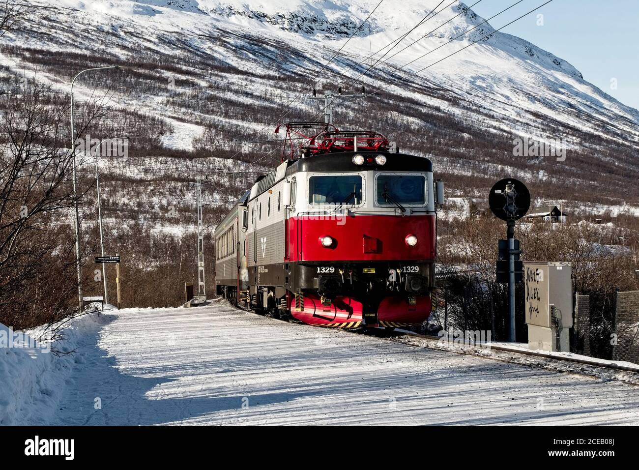 Modern train going through Nordic countryside in winter. Stock Photo
