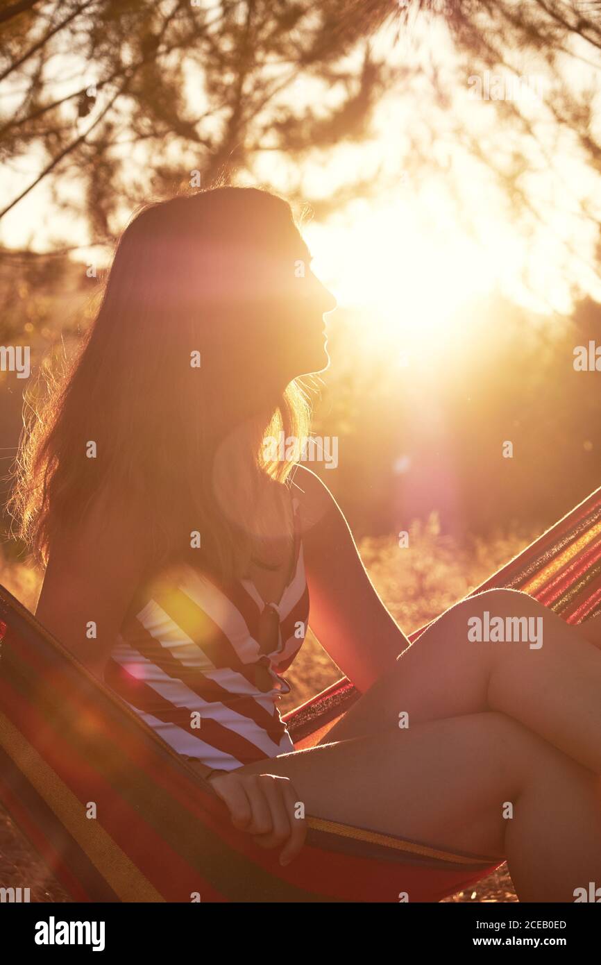 Tanned female on hammock at sunny glade Stock Photo