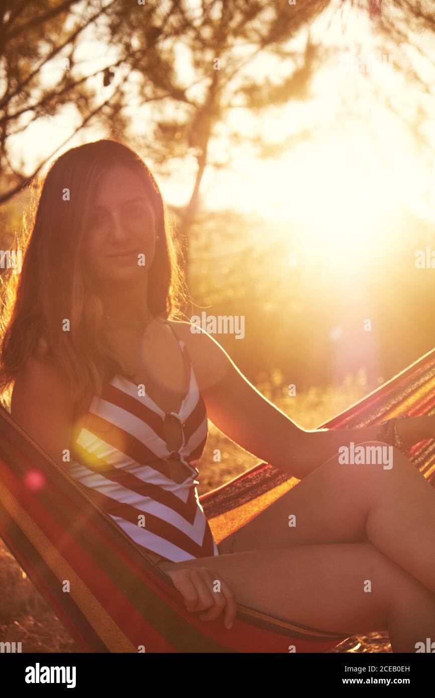 Tanned female on hammock at sunny glade Stock Photo