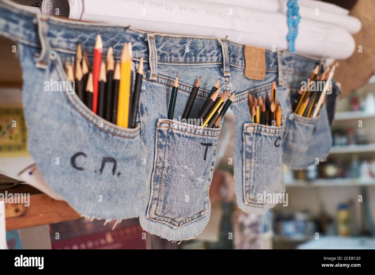 Creative pen case made of jeans pockets full of writing pencils hanging in  room Stock Photo - Alamy