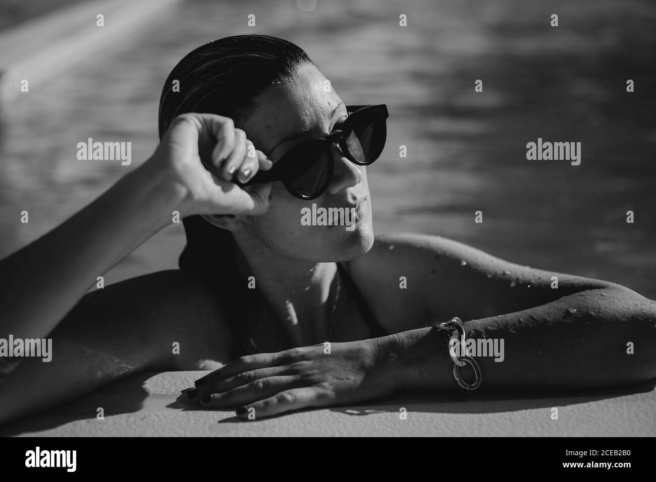 Young Woman in sunglasses in pool Stock Photo