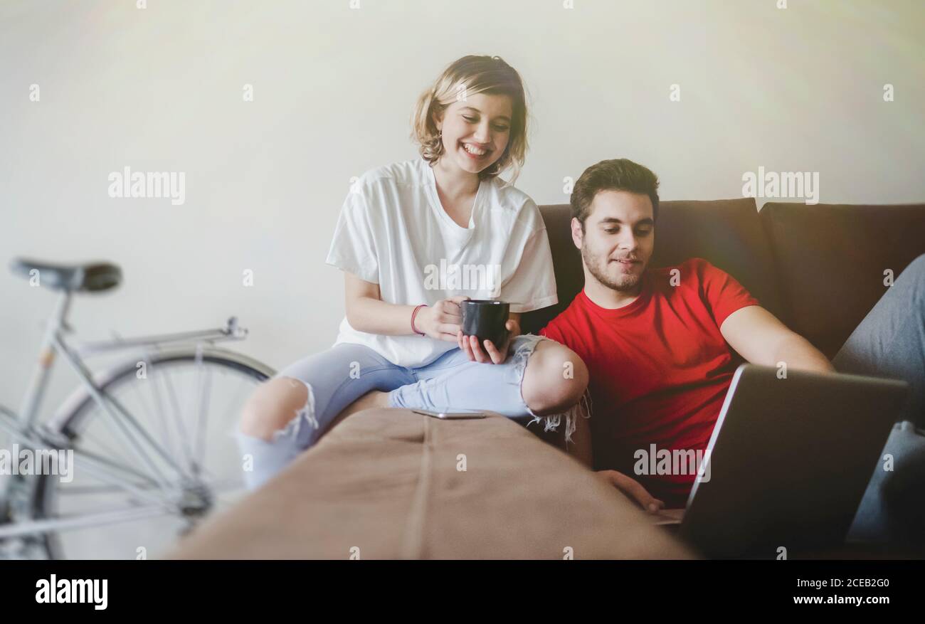 Cheerful couple laying down on the couch with computer Stock Photo