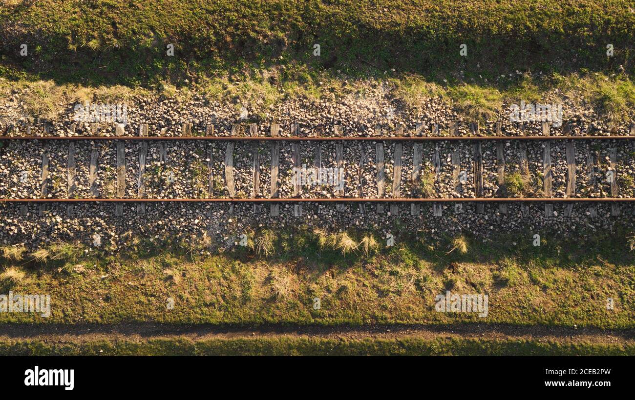 Old railway above dirty river in forest on sunlight with? trees Stock Photo