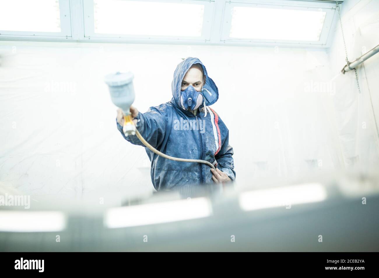 painter posing in front of the booth before painting a car Stock Photo