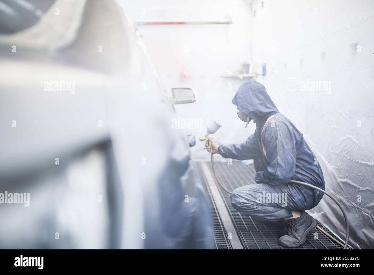 painter posing in front of the booth before painting a car Stock Photo