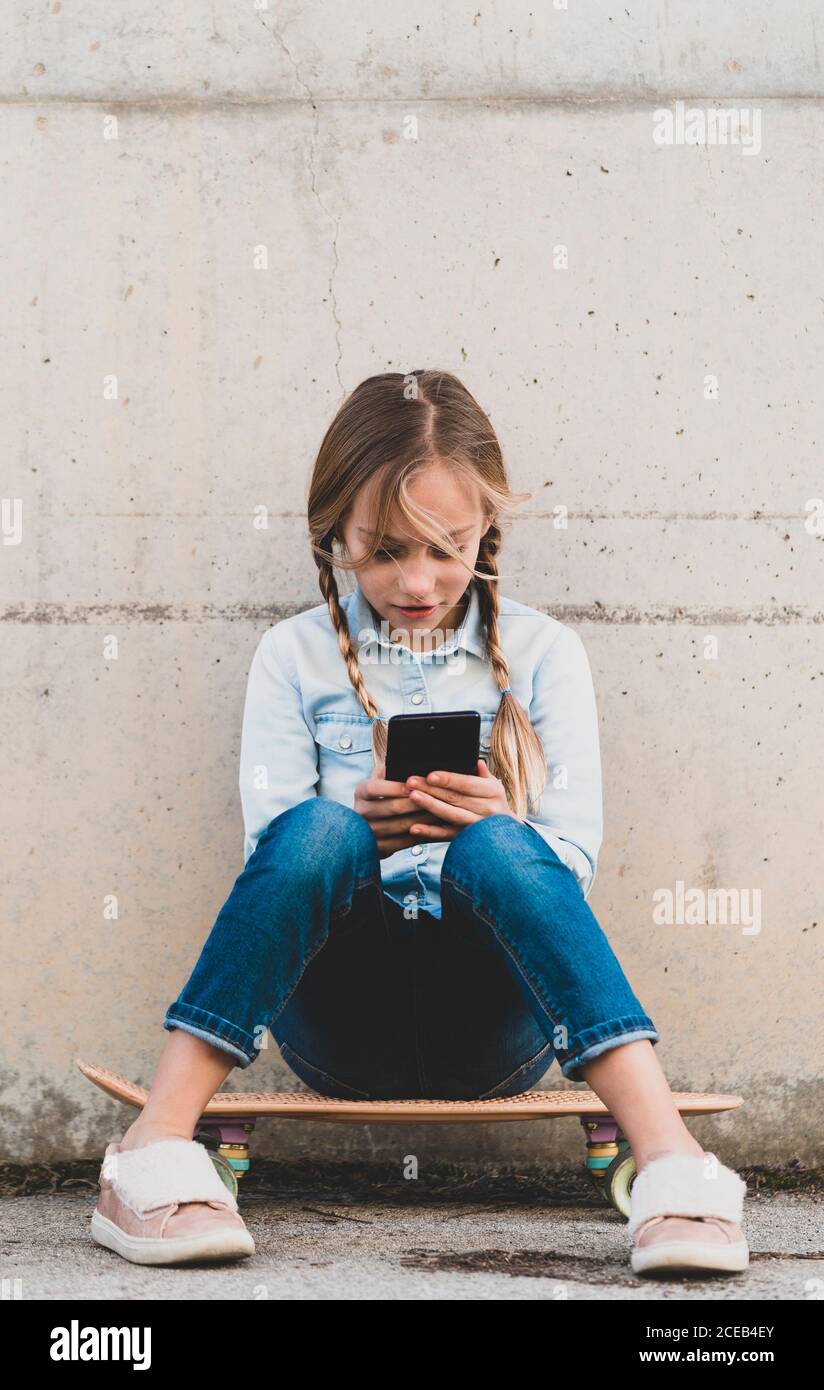 Kid using mobile phone with skate Stock Photo