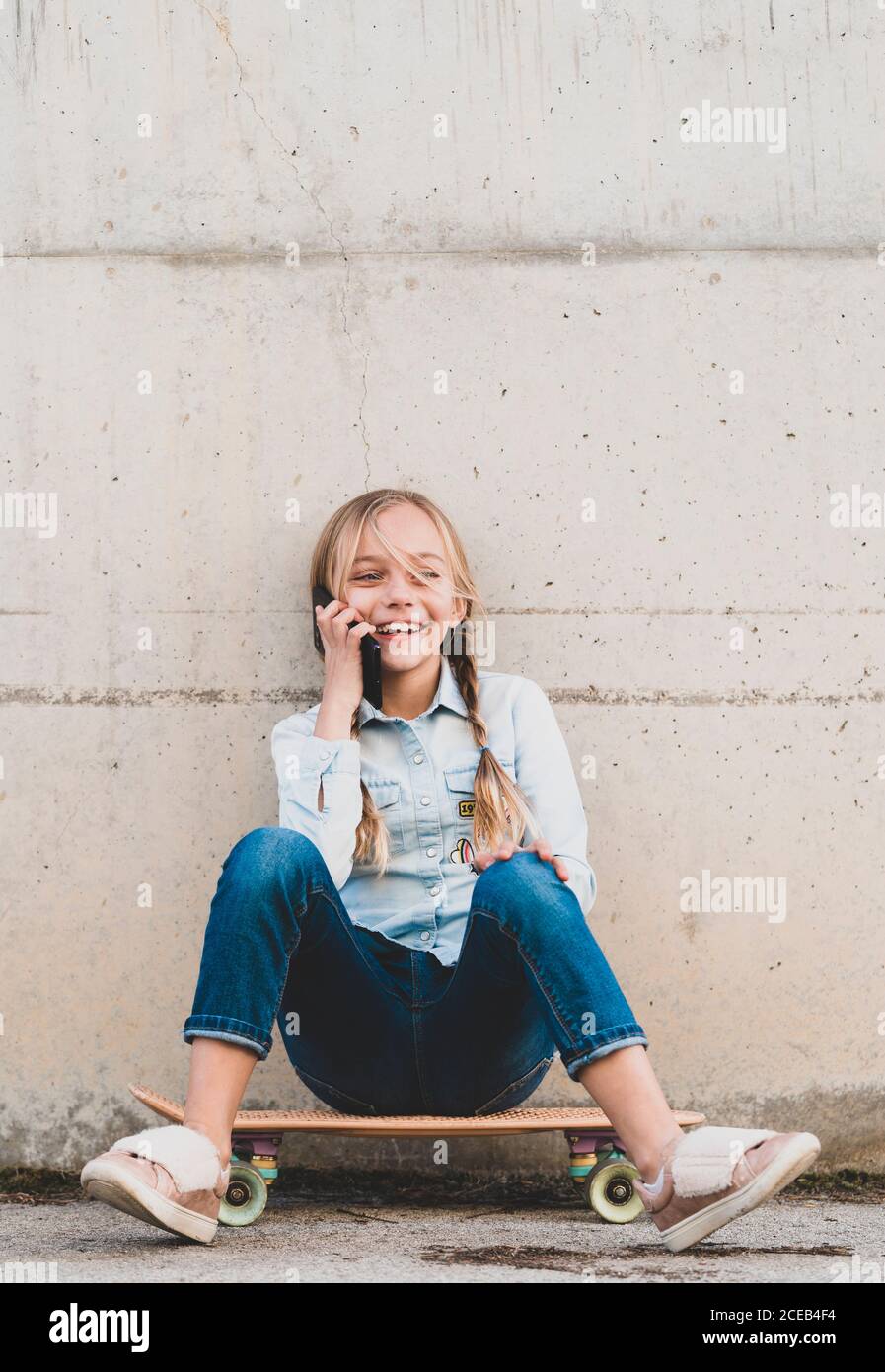 Kid using mobile phone with skate Stock Photo