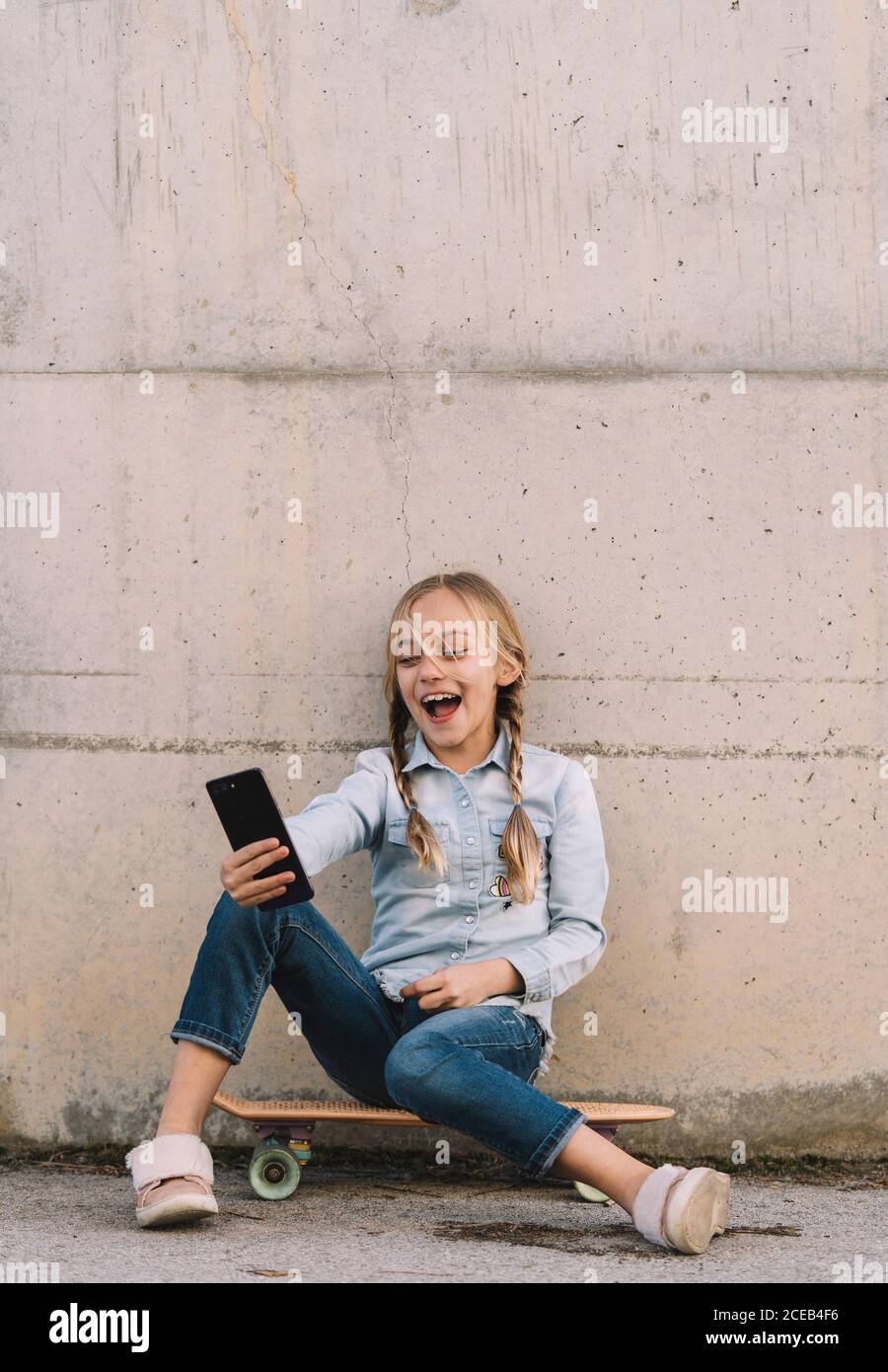 Kid using mobile phone with skate Stock Photo