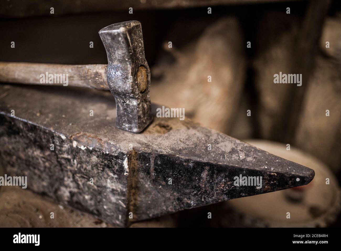 Crop close-up view of hammer lying on metal anvil in casting factory Stock Photo