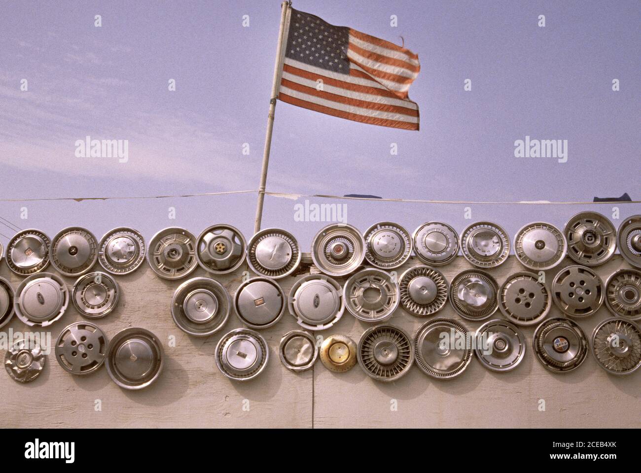 American flag flying over hubcaps. Stock Photo