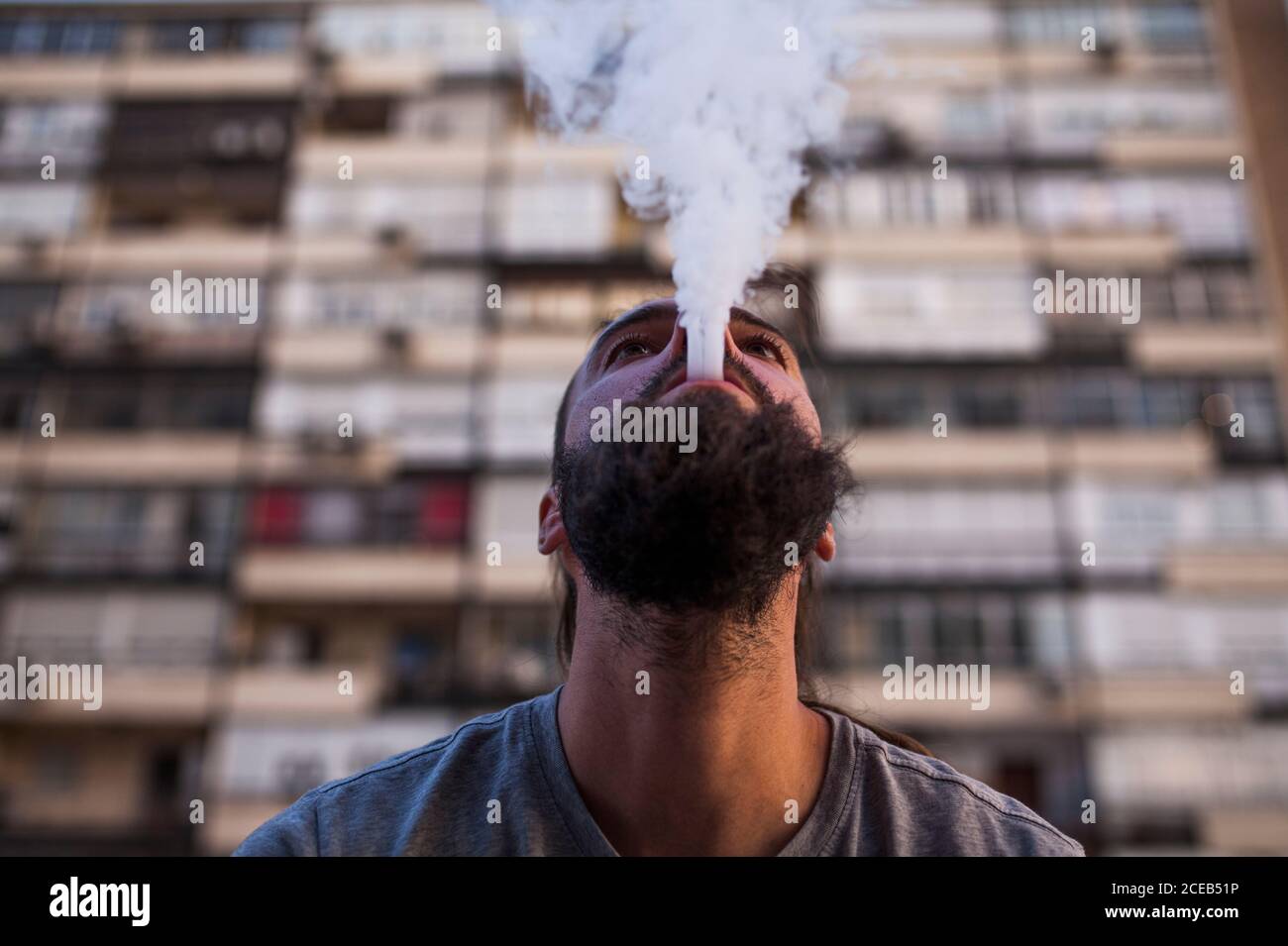 young and Caucasian Rastafarian man smoking and exposing smoke and look up Stock Photo