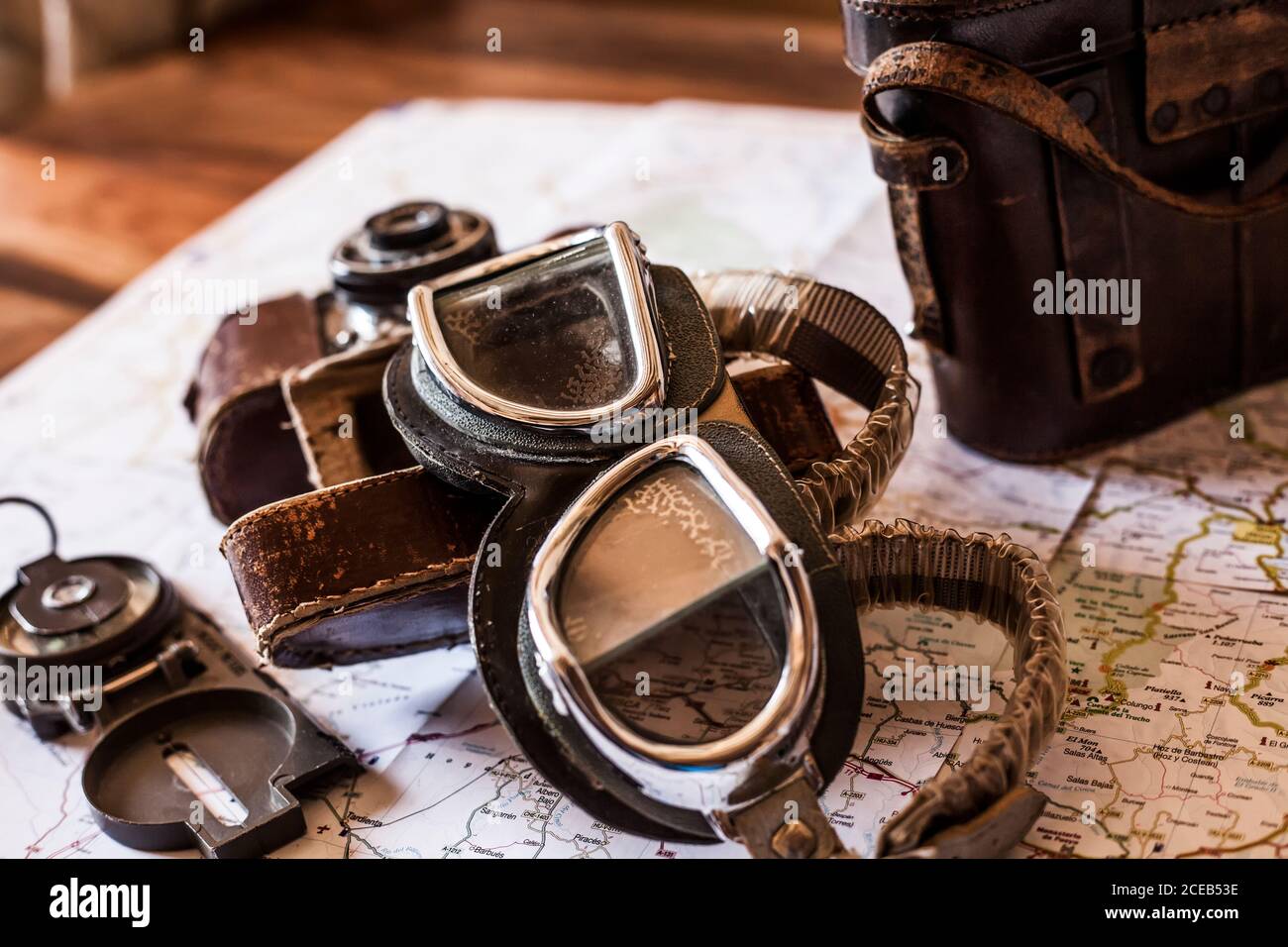 planning a trip on a map with vintage motorcycle glasses, old photo camera, prismatic and compass Stock Photo