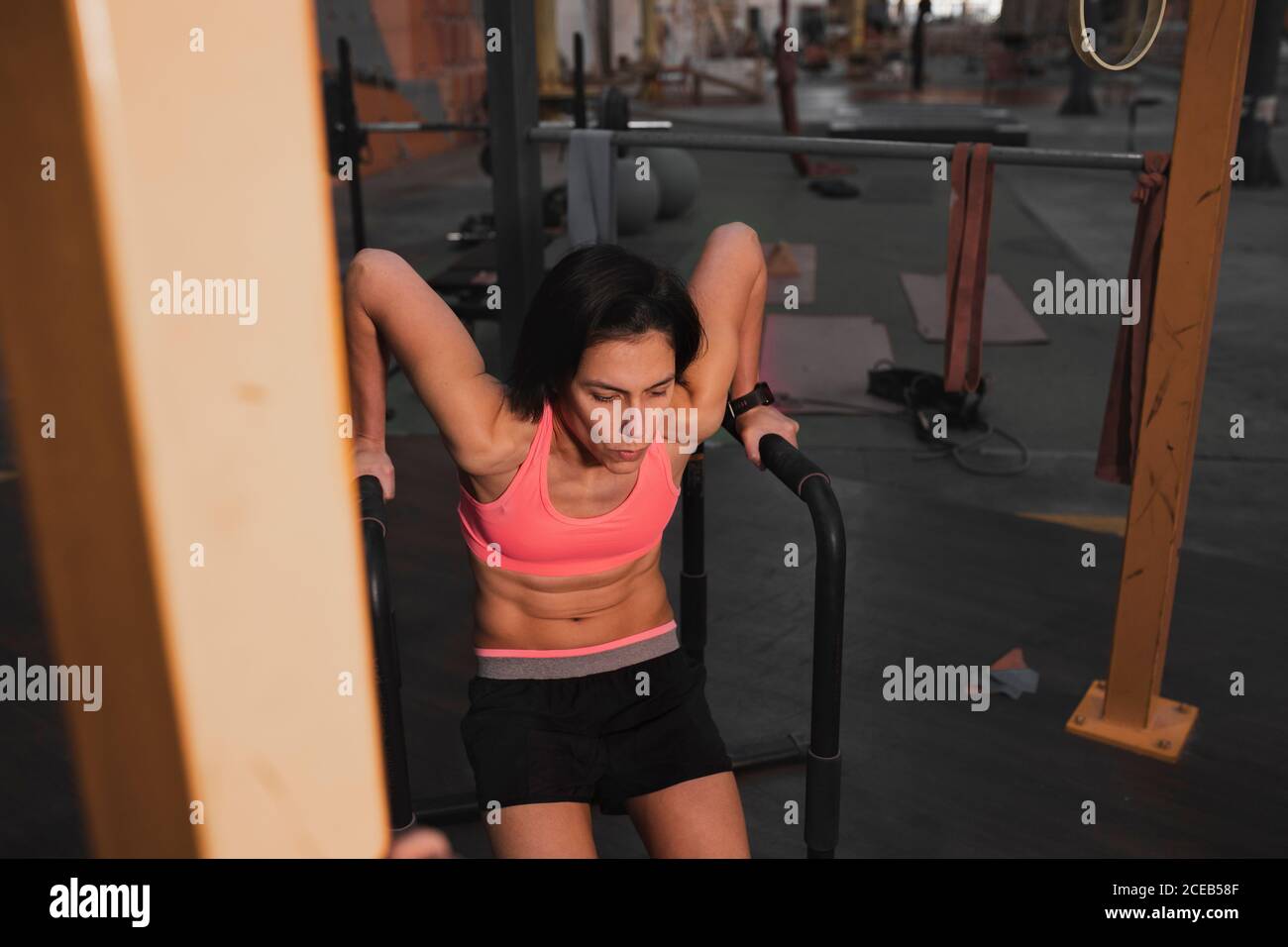 Young slim sportive lady in sportswear doing pull up exercises on ...