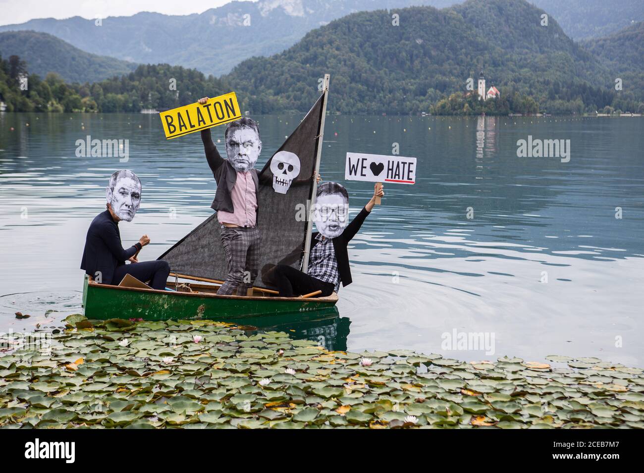 A group of protesters wearing paper masks showing the faces of Slovenian Prime Minister, Janez Jansa, Hungarian Prime Minister, Viktor Orban and Serbian president, Aleksandar Vucic row a small sailboat on Lake Bled protesting against their politics and the rise of fascism in Europe.The protest was held alongside the 15th Bled Strategic Forum where Slovenian Prime Minister Janez Jansa hosted the Hungarian Prime Minister Viktor Orban and Serbian president Aleksandar Vucic, as well as prime ministers of Czech Republic, Bulgaria, Poland, Croatia and others. Stock Photo