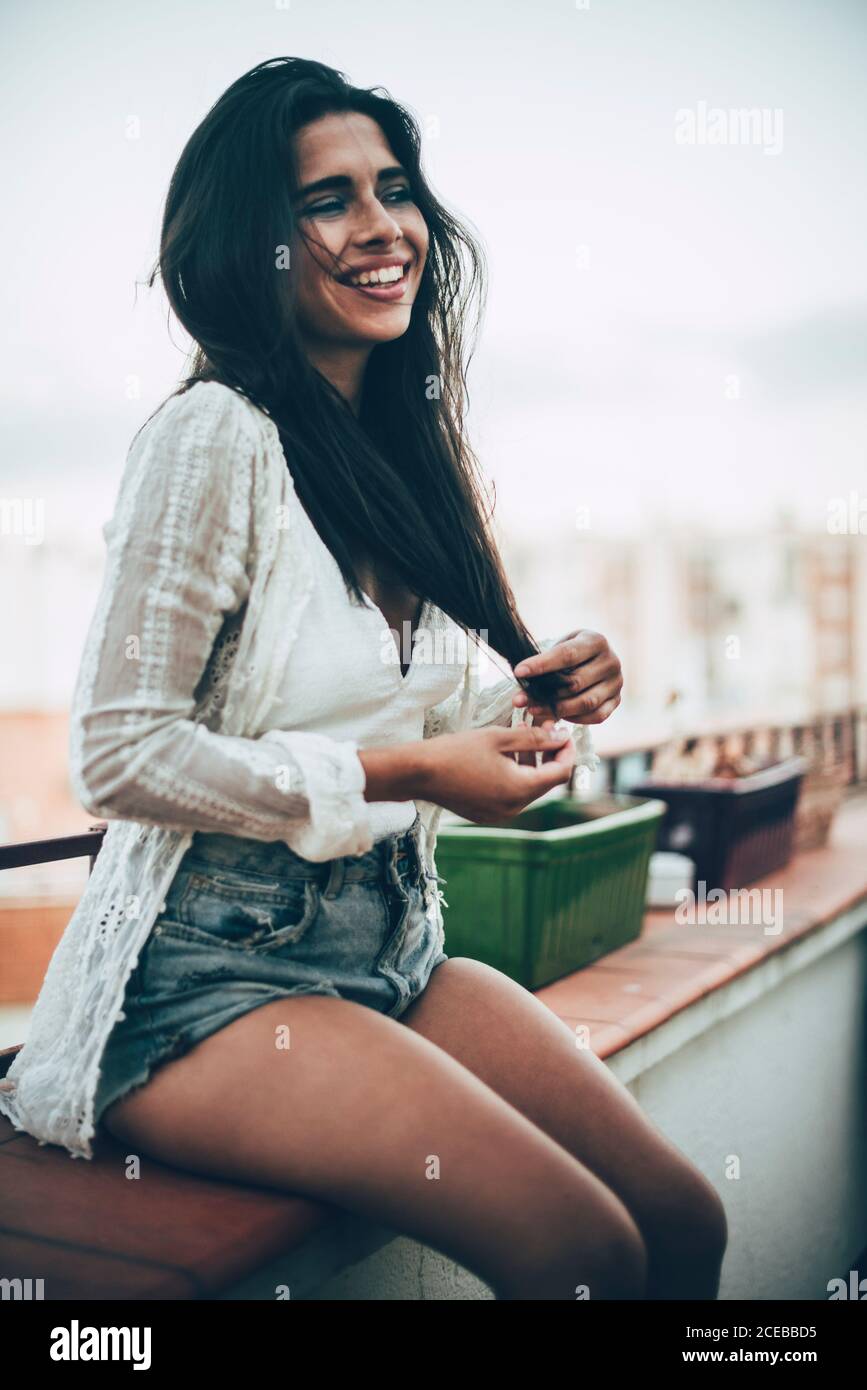 Young Woman sitting at balcony and smiling Stock Photo
