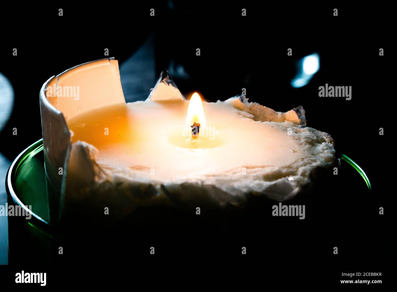 Broken lit candle surrounded by darkness Stock Photo Alamy