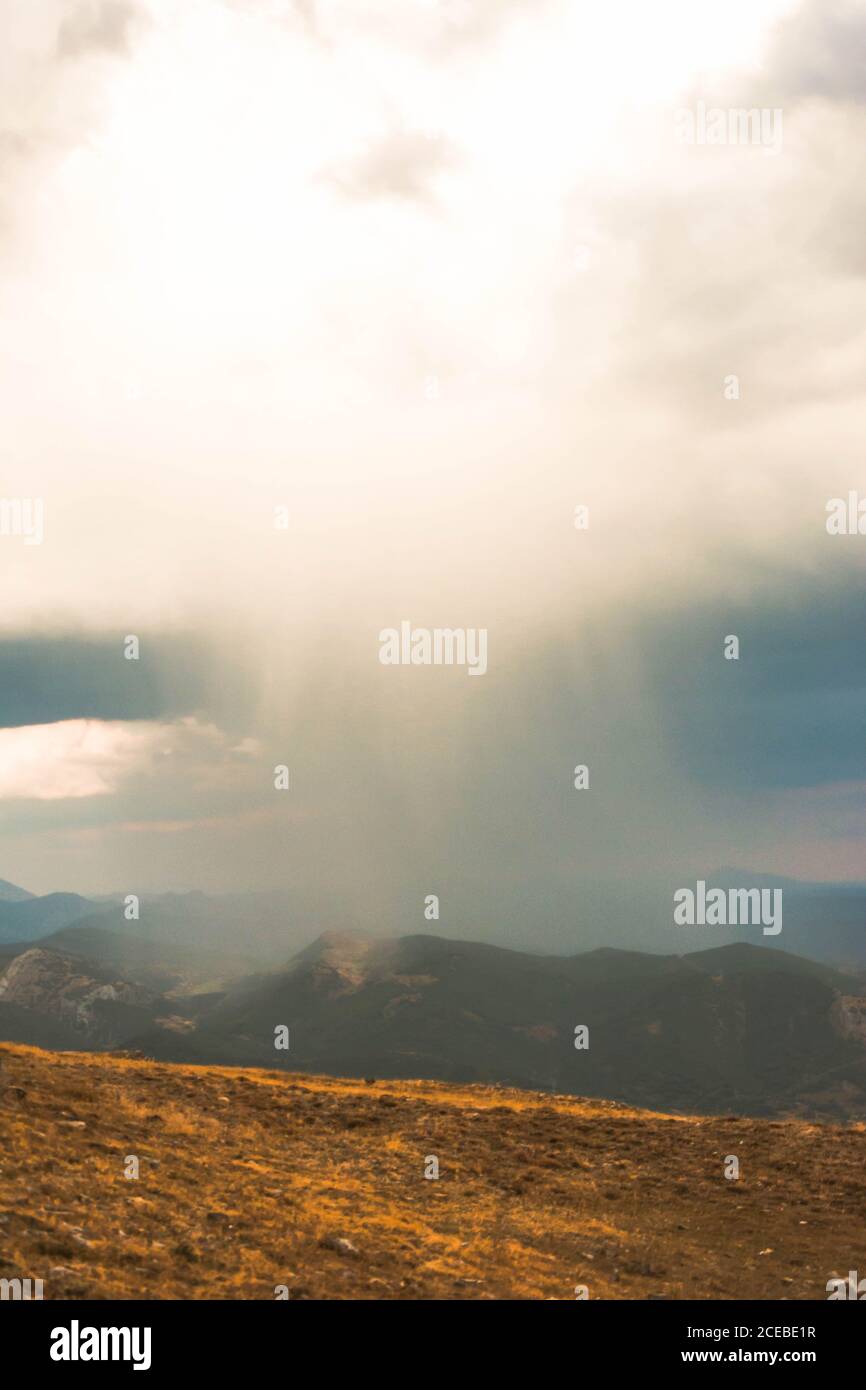 Beautiful mountains in valley with colorful sky and sunbeams above ...