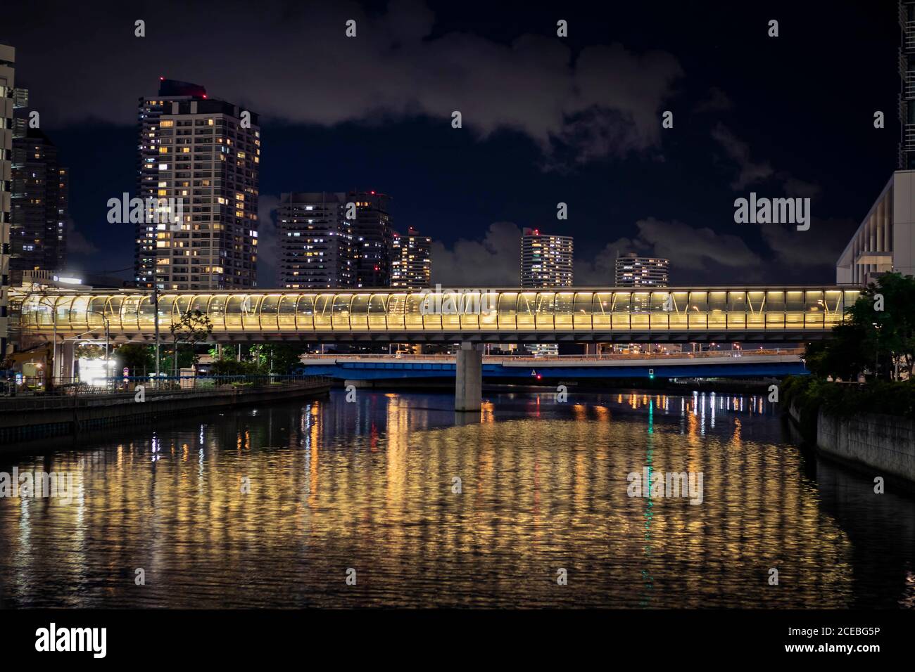 View of the fotbridge connecting the building across the canal in Yokohama during night time. Stock Photo