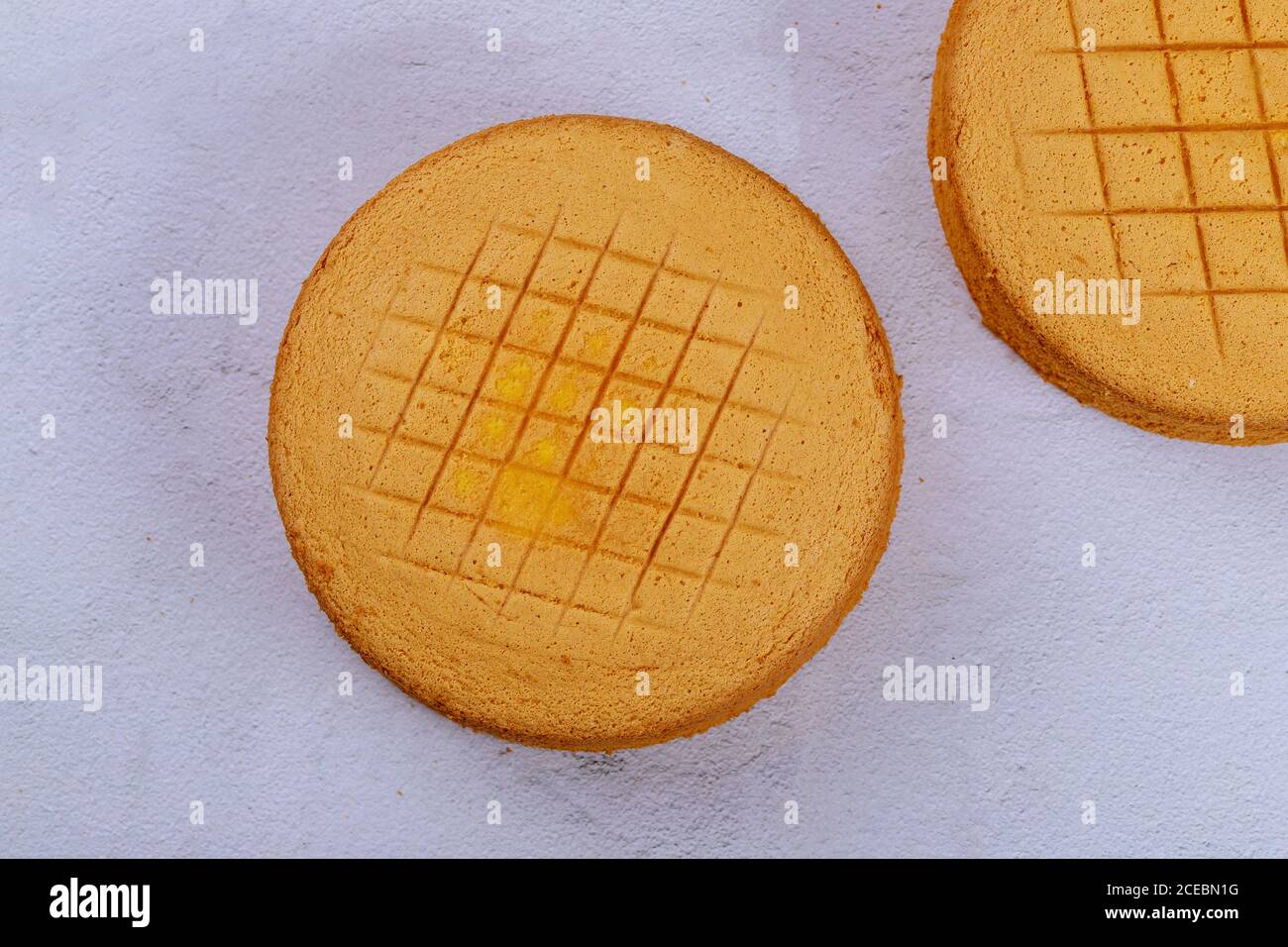 Textured sponge cake on white surface. Top view. Stock Photo