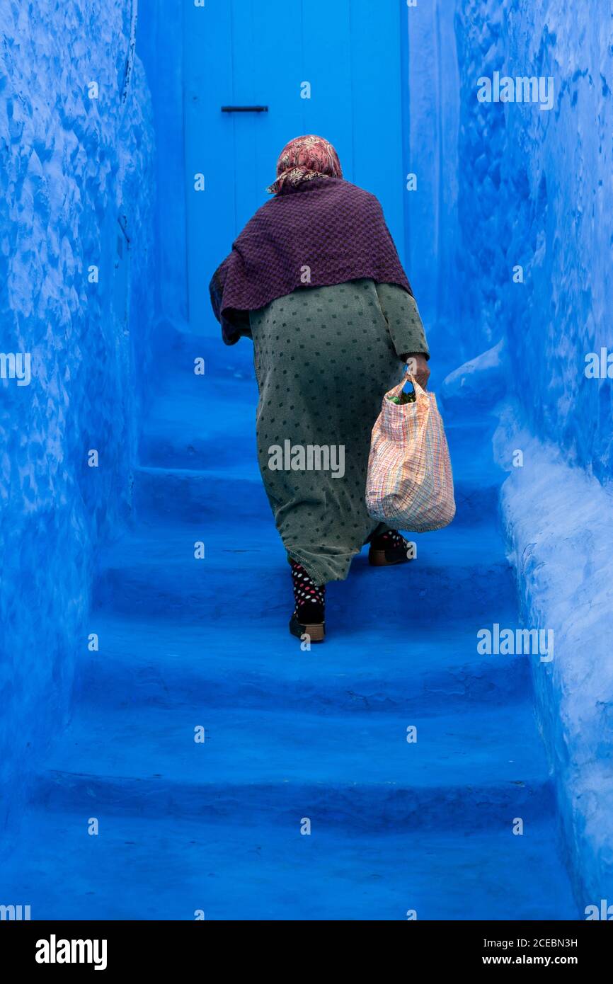 Old Woman climbing the blue stairs Stock Photo Alamy