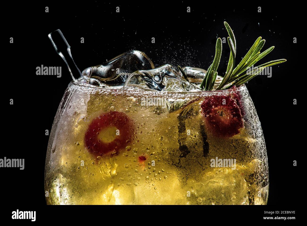 closeup of bubbly red gin tonic with cucumber and pepper Stock Photo