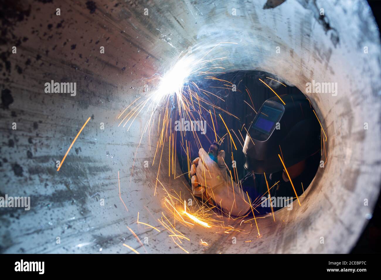 Asian workers wearing safety first uniforms and Welded Iron Mask at Steel welding plants, industrial safety first concept. Stock Photo