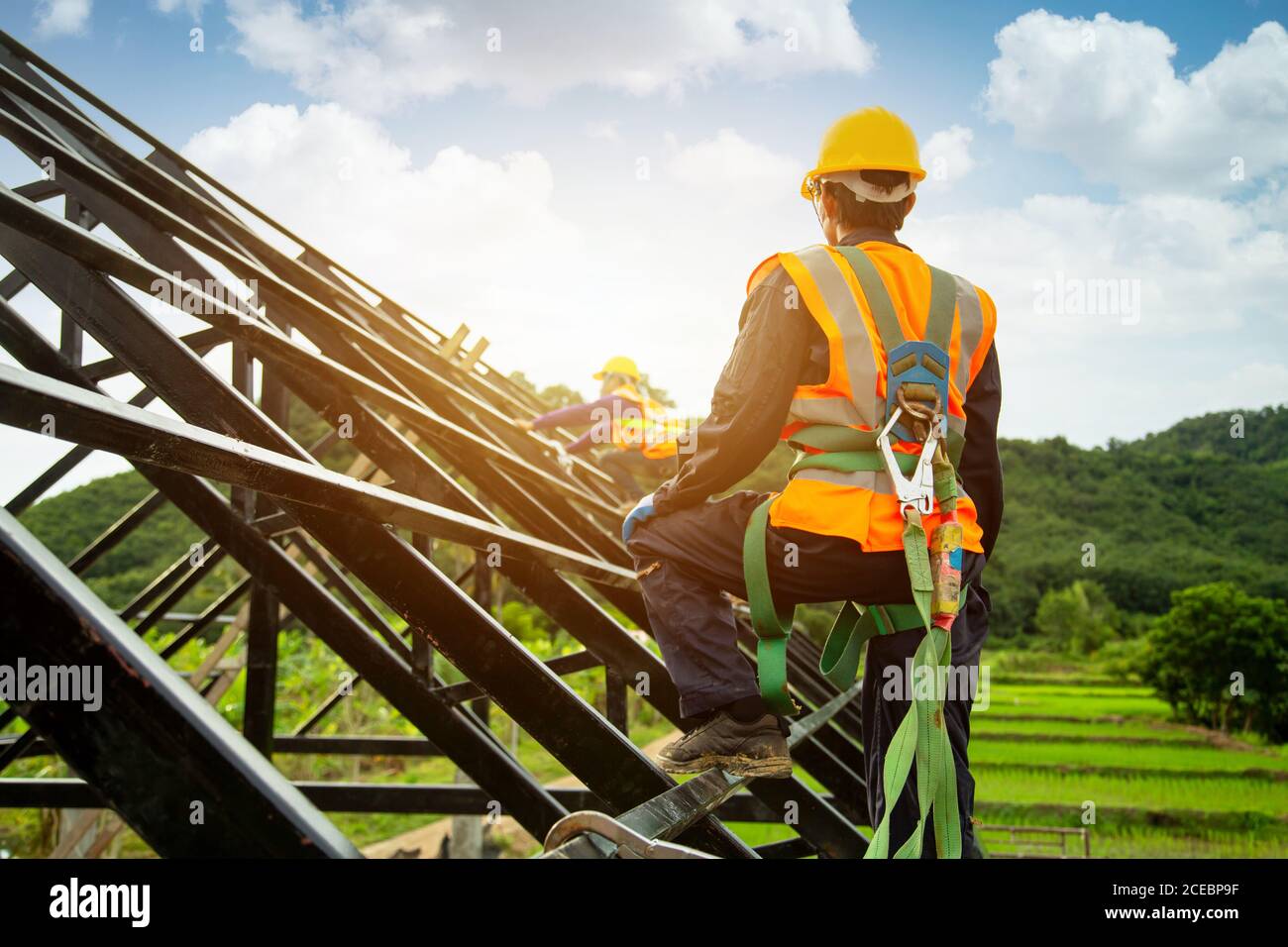 Asian worker wear safety height equipment to install the roof. Fall arrestor device for worker with hooks for safety body harness, Worker as in the co Stock Photo
