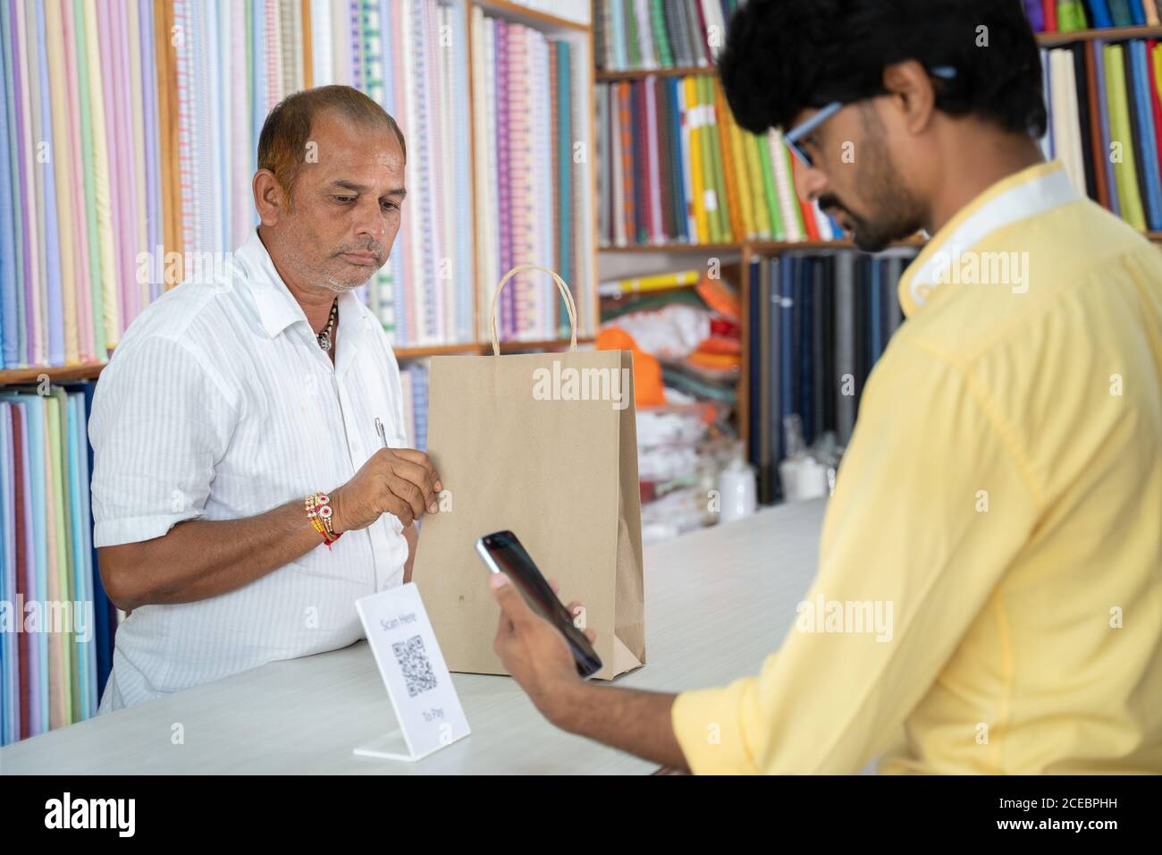 Customer using digital payment method scan to pay at cloth store to send money - concept of digital or contactless payment, e-transfer, technology and Stock Photo