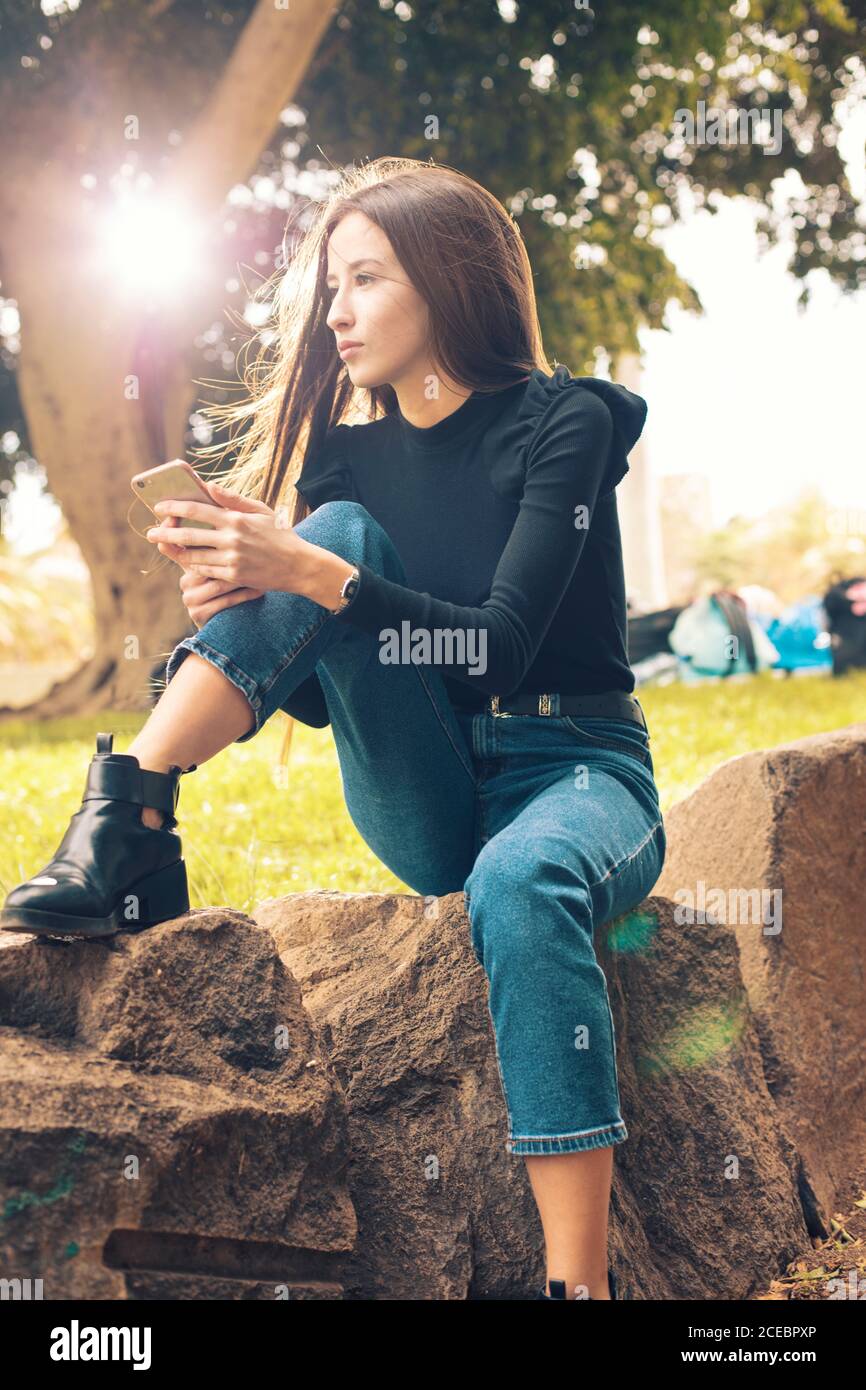 Young Woman using smartphone in park Stock Photo