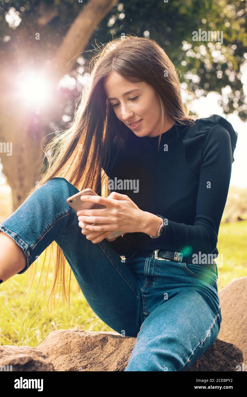 Young Woman using smartphone in park Stock Photo