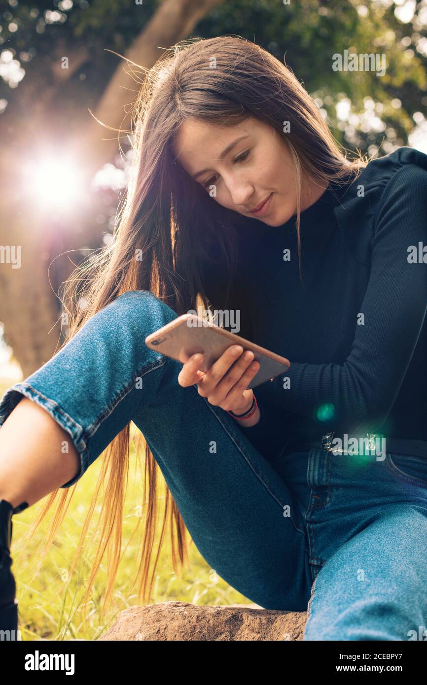 Young Woman using smartphone in park Stock Photo