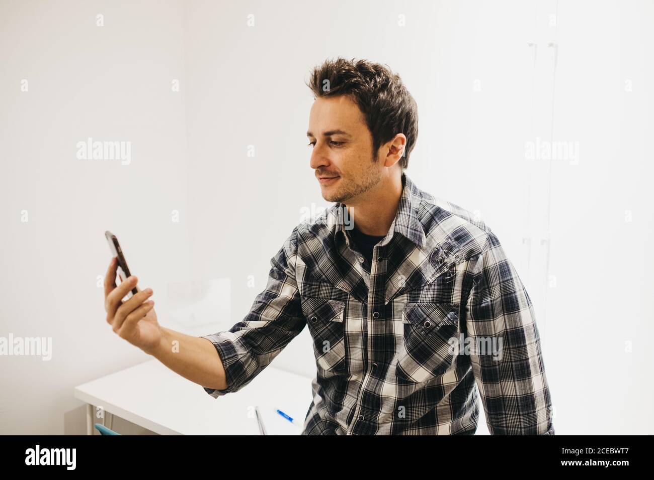 Smiling young man taking selfie on smartphone Stock Photo