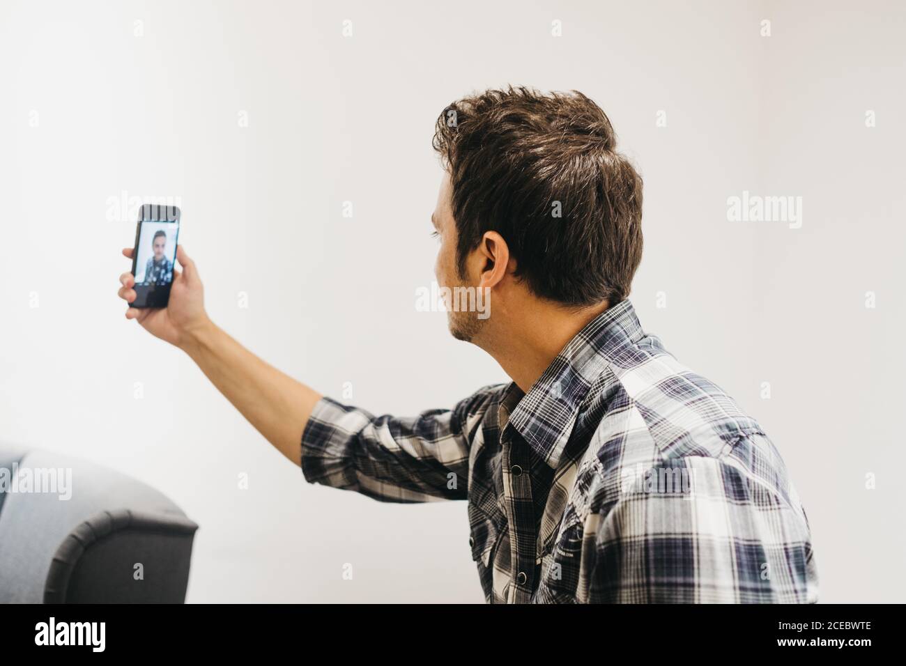 Smiling young man taking selfie on smartphone Stock Photo