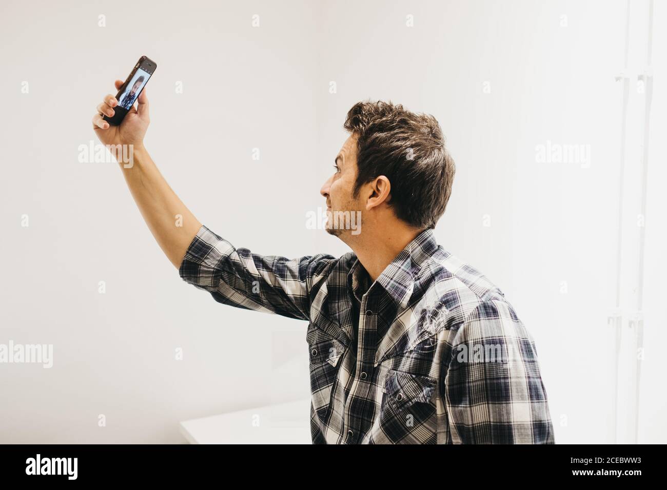 Smiling young man taking selfie on smartphone Stock Photo