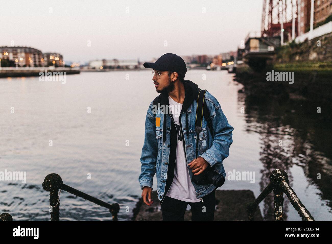 Cheerful man with camera on embankment Stock Photo
